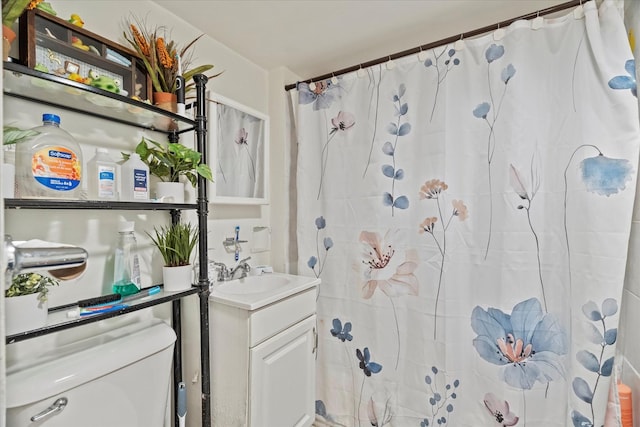 bathroom with vanity, curtained shower, and toilet