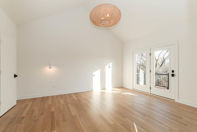 unfurnished living room with high vaulted ceiling and light hardwood / wood-style floors