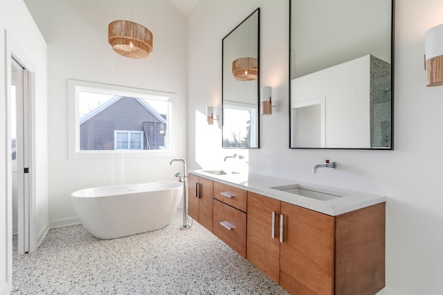 bathroom featuring lofted ceiling, vanity, and a bathing tub