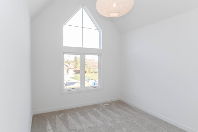 spare room with lofted ceiling and light carpet