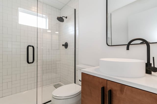 bathroom featuring vanity, toilet, and an enclosed shower