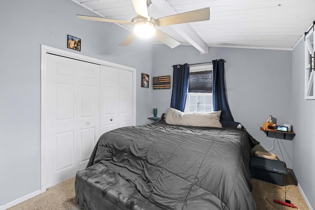 carpeted bedroom featuring vaulted ceiling with beams, a closet, ceiling fan, and wooden ceiling