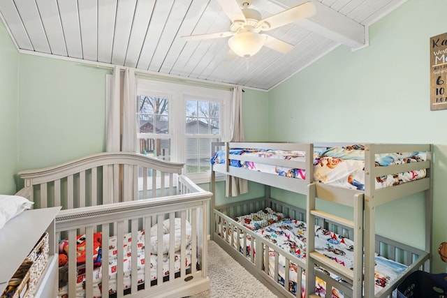 bedroom with wood ceiling, ceiling fan, lofted ceiling with beams, a crib, and carpet floors