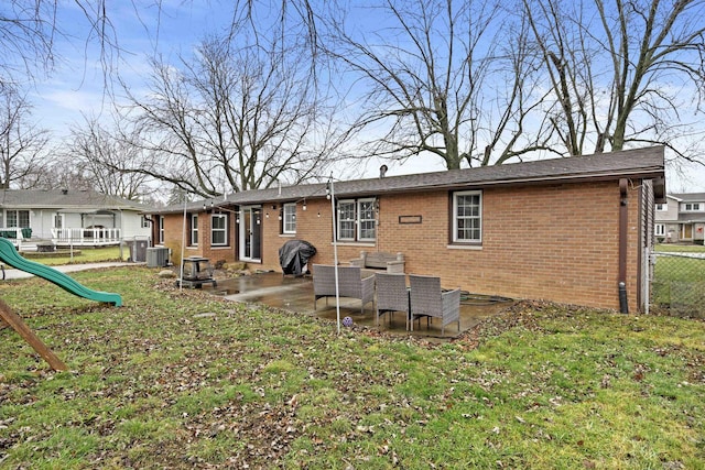 back of property featuring a playground, a lawn, cooling unit, and a patio