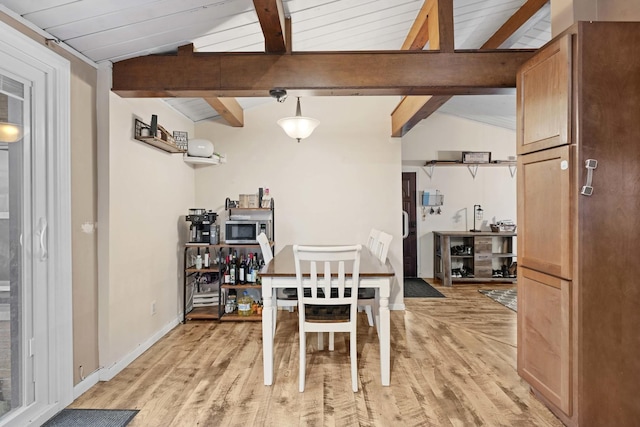 dining space featuring light wood-type flooring, lofted ceiling with beams, and wooden ceiling