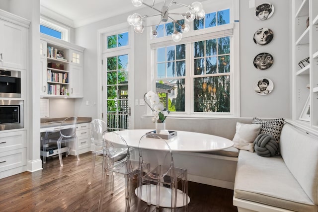 dining area with breakfast area, crown molding, and dark wood-type flooring