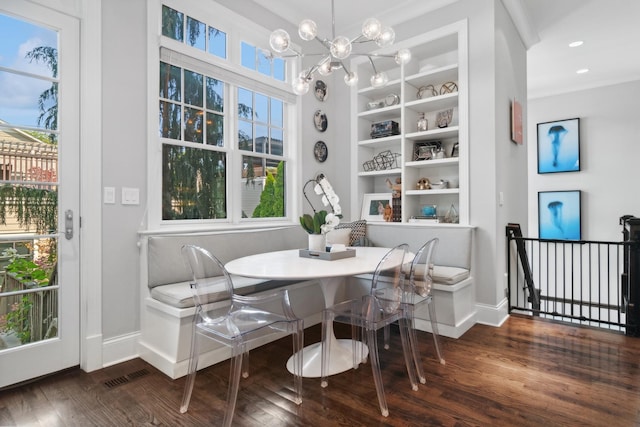 dining room with a chandelier, plenty of natural light, and dark wood-type flooring