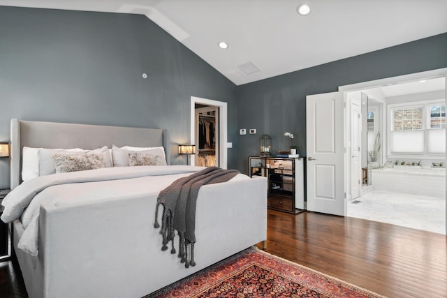 bedroom with hardwood / wood-style flooring, a walk in closet, lofted ceiling, and a closet