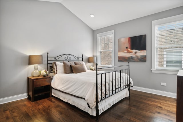 bedroom featuring dark hardwood / wood-style floors, vaulted ceiling, and multiple windows