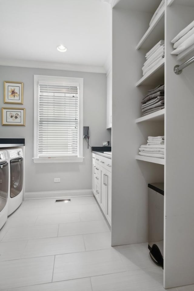 washroom with washing machine and dryer, light tile patterned floors, cabinets, and ornamental molding