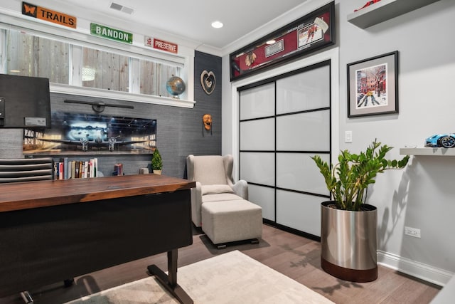 living area featuring hardwood / wood-style floors and ornamental molding