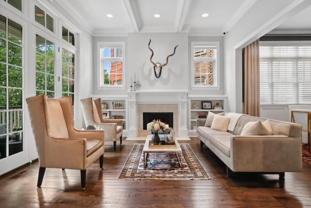 sitting room with beamed ceiling, built in shelves, dark hardwood / wood-style floors, and crown molding