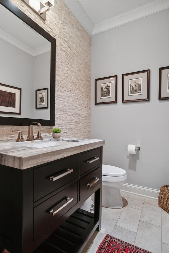 bathroom featuring tile patterned flooring, vanity, toilet, and crown molding