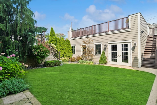 back of house with a balcony, a yard, and french doors