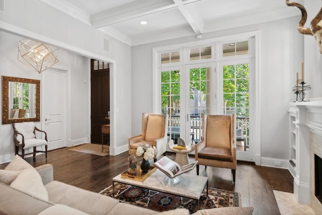 living room with beam ceiling, a fireplace, dark hardwood / wood-style flooring, and a chandelier