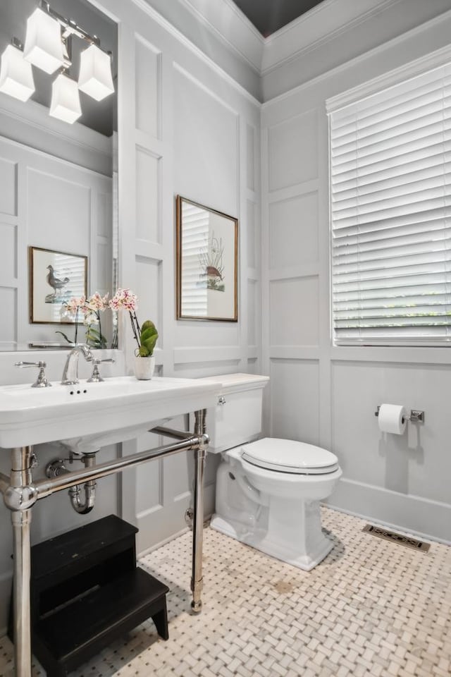 bathroom with toilet and crown molding