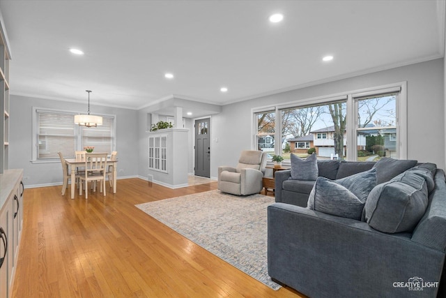 living room with light hardwood / wood-style floors and crown molding