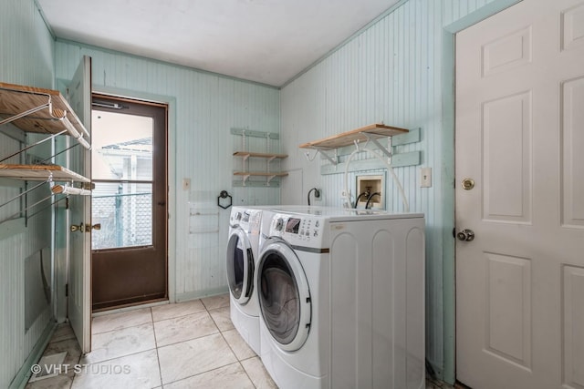 washroom with independent washer and dryer, wood walls, and light tile patterned flooring