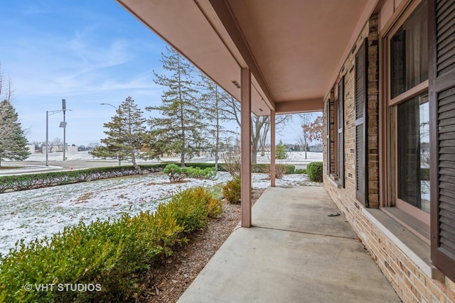 snow covered patio featuring covered porch