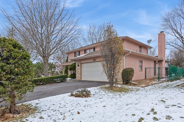 view of snowy exterior with a garage