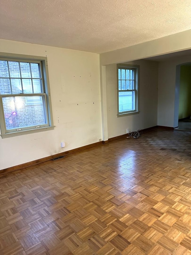 unfurnished room featuring a textured ceiling and light parquet floors