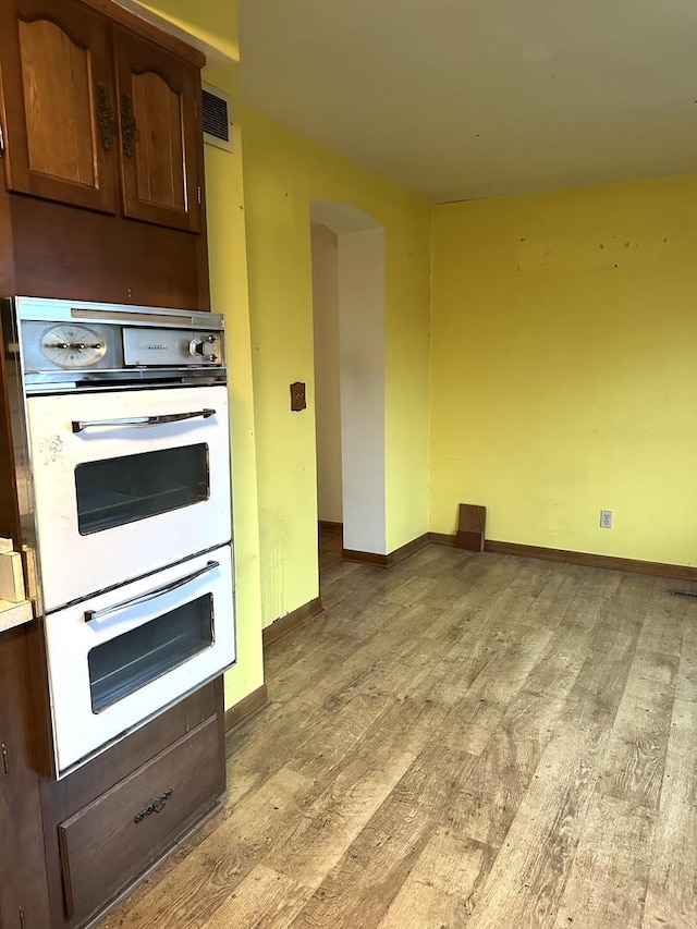 kitchen featuring light hardwood / wood-style floors and white double oven