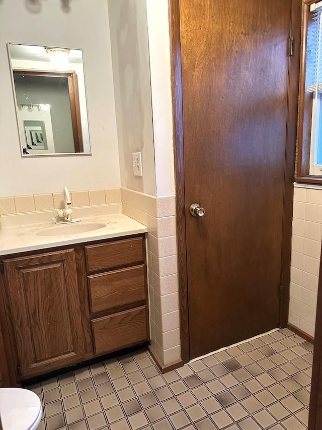 bathroom featuring vanity and tile walls