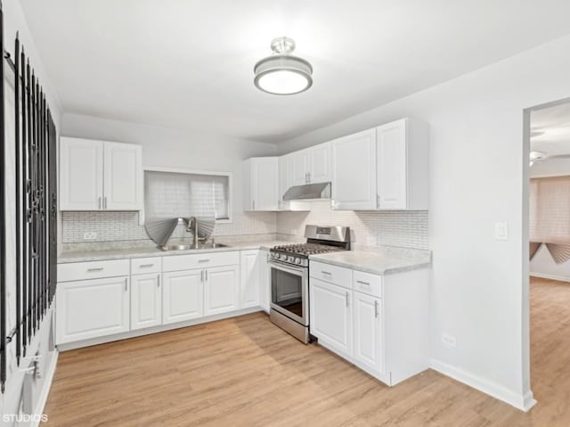 kitchen featuring white cabinetry, stainless steel gas stove, light hardwood / wood-style flooring, and sink