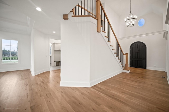 entrance foyer with light hardwood / wood-style floors and an inviting chandelier