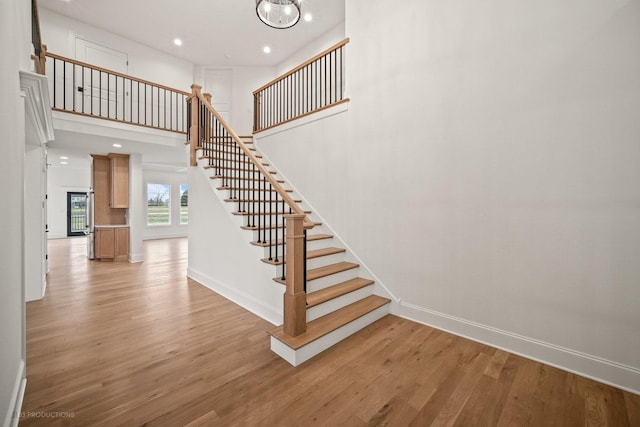 stairs with a high ceiling and hardwood / wood-style flooring