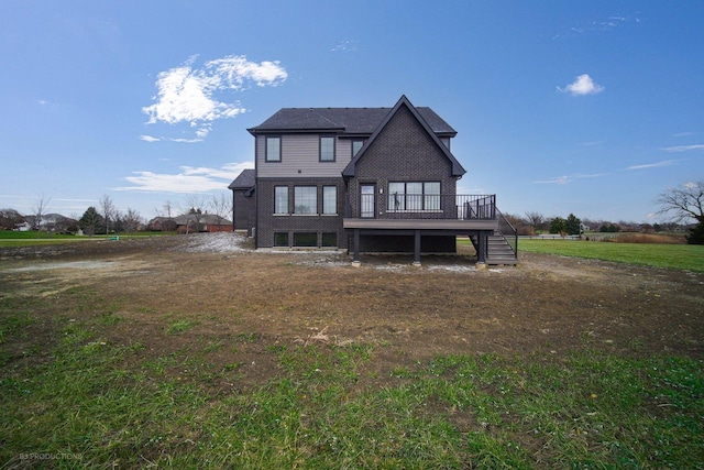 rear view of property featuring a lawn and a deck