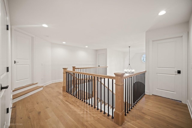 hall featuring an inviting chandelier and light hardwood / wood-style flooring