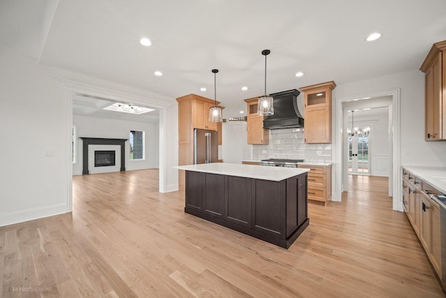 kitchen with appliances with stainless steel finishes, light hardwood / wood-style floors, custom range hood, and a healthy amount of sunlight