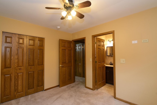 carpeted bedroom featuring connected bathroom, ceiling fan, and a closet