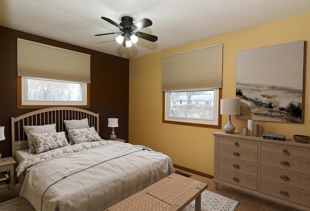 bedroom with ceiling fan, carpet floors, and multiple windows