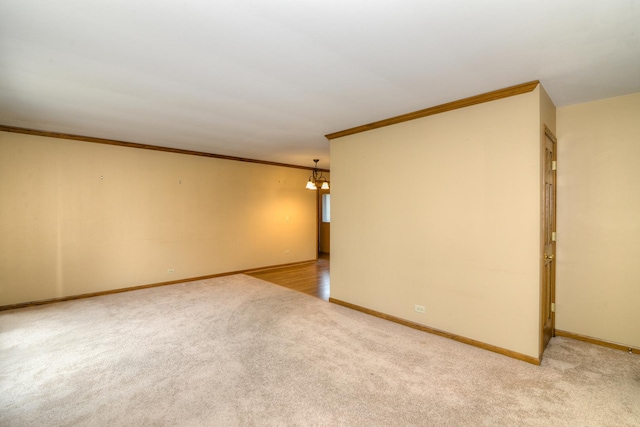 unfurnished room with ornamental molding, light colored carpet, and a notable chandelier