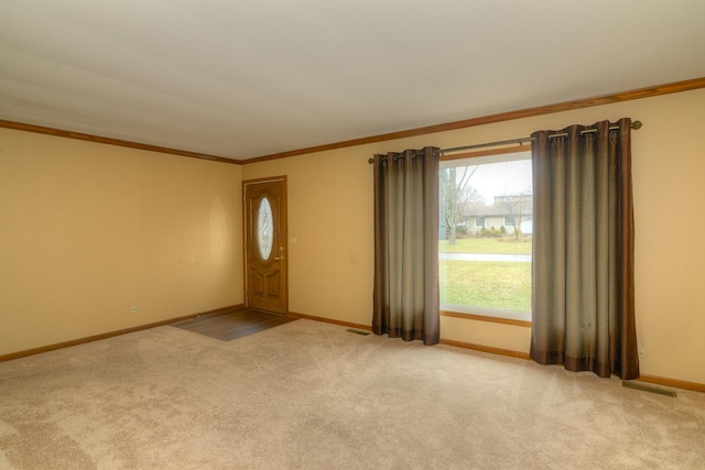 carpeted entryway featuring a healthy amount of sunlight and ornamental molding