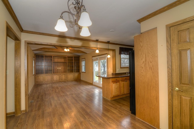 kitchen featuring an inviting chandelier, crown molding, hanging light fixtures, and dark wood-type flooring