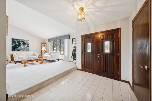 foyer entrance with light tile patterned flooring and lofted ceiling