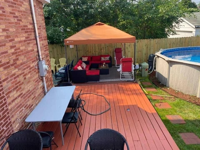 wooden deck with a fenced in pool and an outdoor hangout area