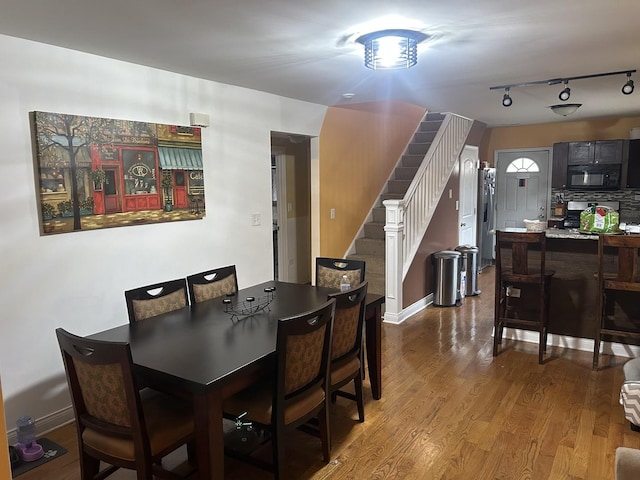 dining room featuring hardwood / wood-style flooring and track lighting