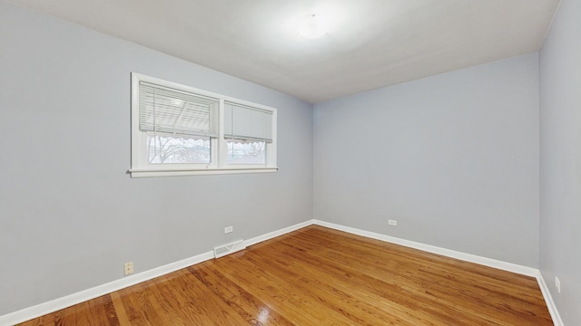 unfurnished room with hardwood / wood-style flooring