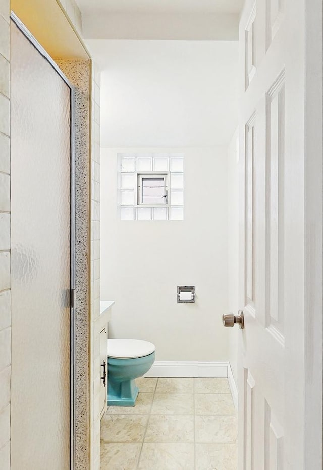 bathroom with tile patterned floors, toilet, and a shower with shower door