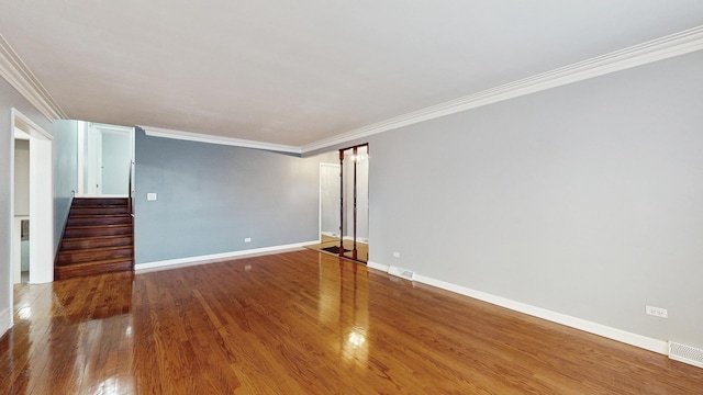 empty room with hardwood / wood-style floors and crown molding