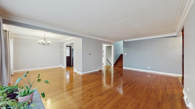 unfurnished living room featuring hardwood / wood-style floors, a notable chandelier, and crown molding