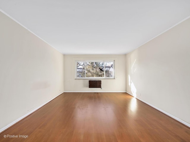 unfurnished living room with heating unit and hardwood / wood-style flooring