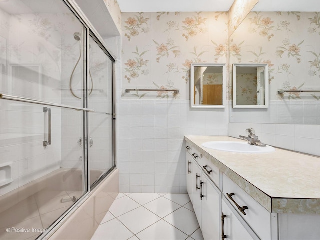 bathroom featuring tile walls, vanity, bath / shower combo with glass door, and tile patterned floors