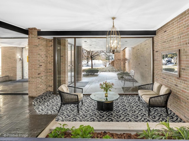 dining space with brick wall, an inviting chandelier, and beam ceiling