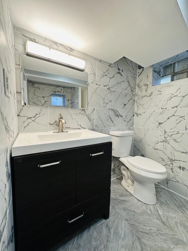 bathroom featuring toilet, plenty of natural light, and tile walls