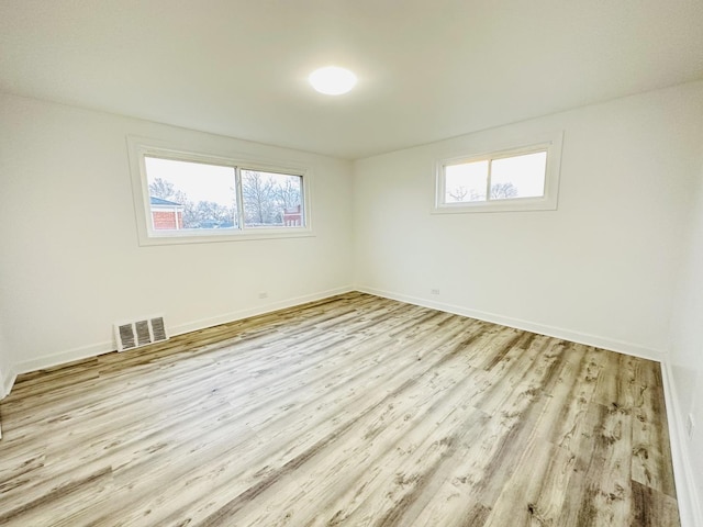 unfurnished room featuring a wealth of natural light and light wood-type flooring